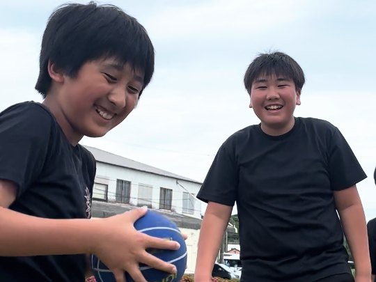 ボールを持って笑い合う子どもたち