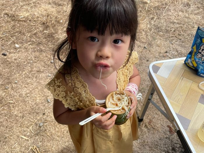 竹の器でそうめんを食べる子ども