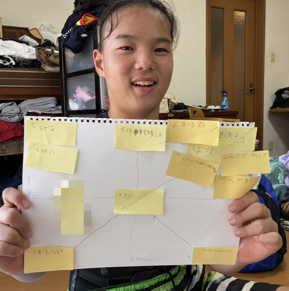 好き・得意の2軸に運動の付箋を貼った台紙を持つ子ども